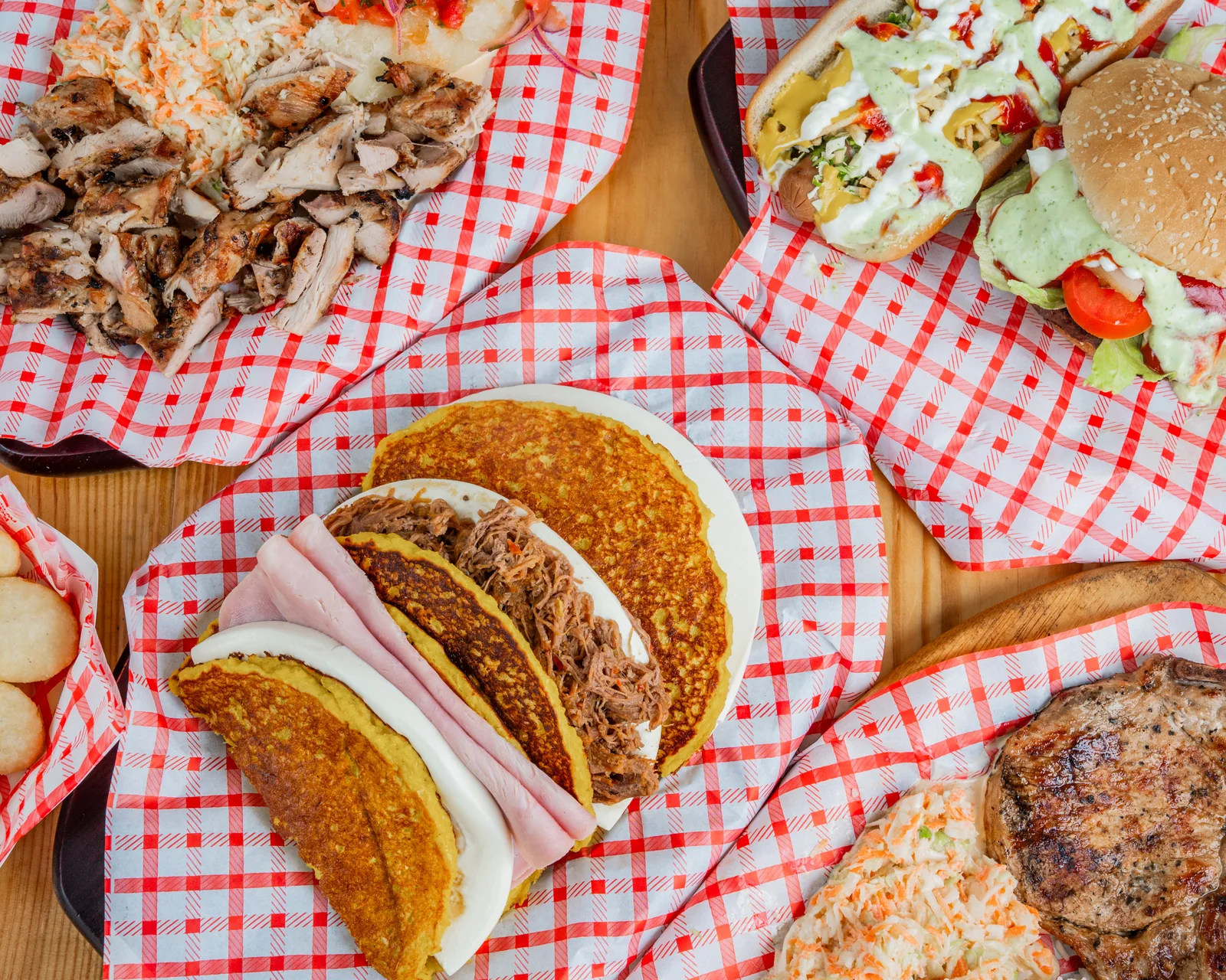 Cachapas, arepas y hamburguesa en la mesa